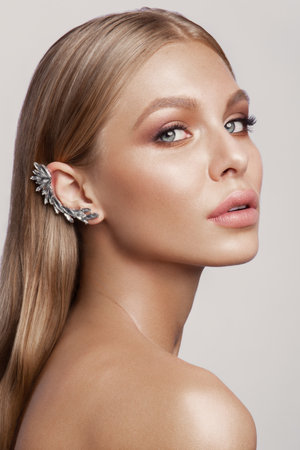 Beauty portrait of model with natural make-up. Fashion shiny highlighter on skin, sexy gloss lips make-upの写真素材