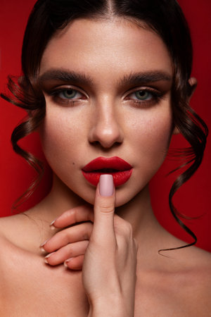 Beautiful woman with perfect skin on red background. Beauty and skin care concept.の写真素材