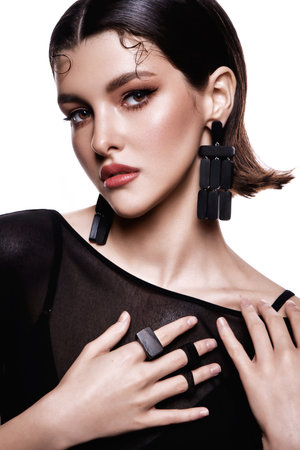 Glamour portrait of beautiful girl model with makeup and romantic hairstyle. Fashion shiny highlighter on skin, gloss lips make-up and dark eyebrows. Pink lipsの写真素材