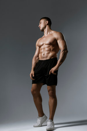 A Muscular Male Model captured in a Profile Pose with Dramatic HighContrast Lightingの写真素材