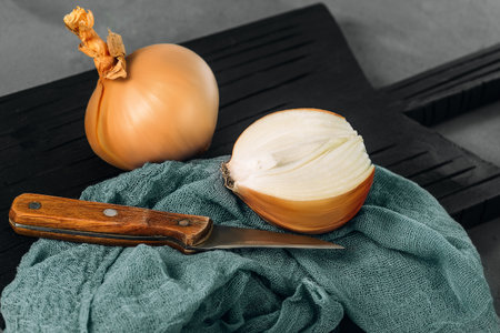 Onion on a black kitchen board. Dark background.の写真素材