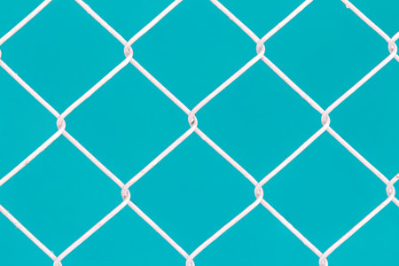 White wire fence on green background