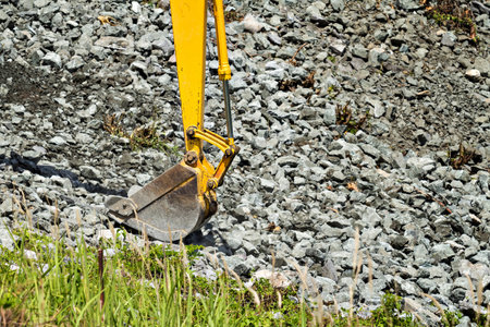 excavator shovel digging rock on constriction siteの写真素材