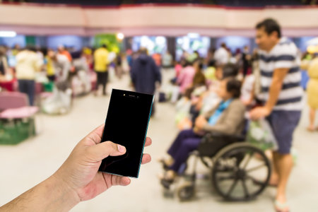 Mobile phone in hand on out-patient department blurred backgroundの写真素材