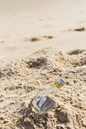 SOS message in glass bottle on the beach.の写真素材