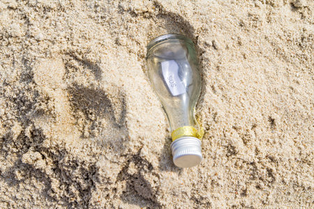 SOS message in glass bottle on the beach.の写真素材