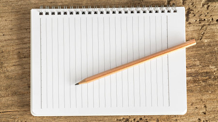 notebook and pencil on wooden table