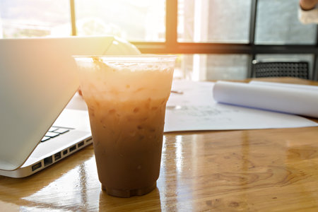 A cup of coffee and laptop in officeの写真素材
