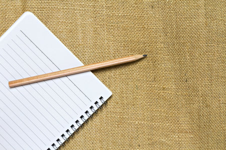 notebook and pencil on burlap linen fabricの写真素材