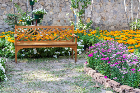 Wooden bench in the colorful flower gardenの写真素材