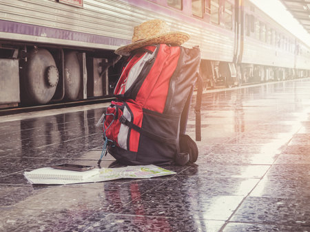 Backpack, hat, cellphone and map on floor at the station. Vintage toneの写真素材