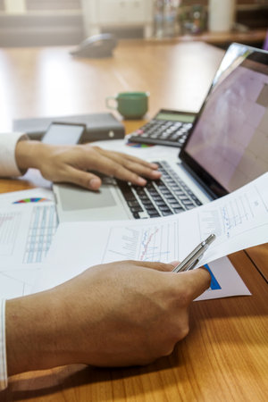 Businessman working with laptop and documents in office
