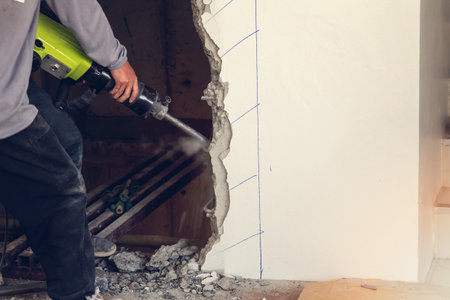 Worker using a jackhammer to drill into wall. professional worker in construction siteの写真素材