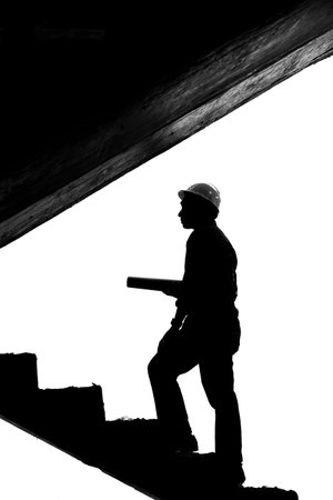 Monochrome image of Engineer with blueprint in building construction siteの写真素材