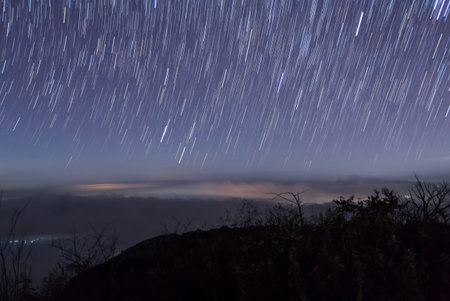 Long exposure image showing star trails over the mountain