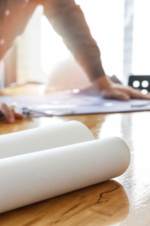 Blueprint on wooden desk with architect background