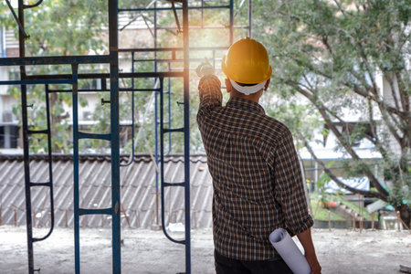 Engineer with blueprint in building construction siteの写真素材