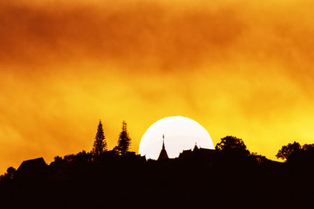 Nice sunset behind Buddhist temple on top of the mountainの写真素材
