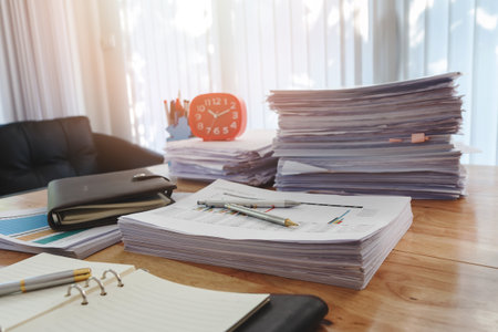 Pen with notebook and documents on wooden table in home office at morningの写真素材