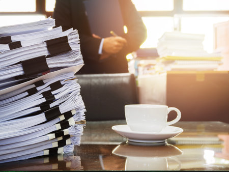 Close up of stack of documents and a cup of coffee on businessman working backgroundの写真素材