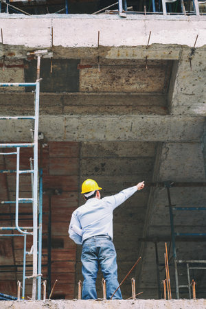 Engineer with blueprint in building construction site
