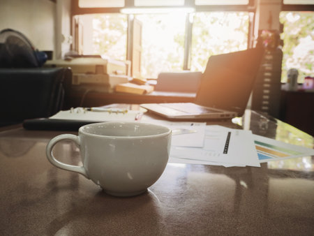 Close up of a cup of coffee and business documents on deskの写真素材