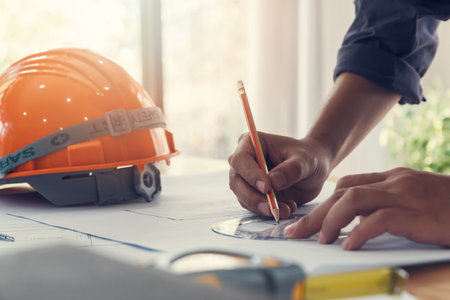 Architect or engineer using pencil and protractor working on blueprint, architectural concept