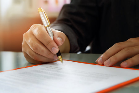 Close up of business man signing contract making a deal, business contract details. Businessman signing an official documentの写真素材