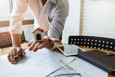 Architect or engineer using pen working on blueprint, architectural concept