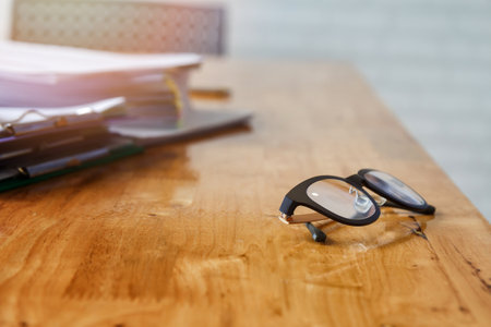 Eye glasses and documents on office deskの写真素材