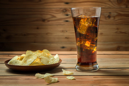 Potato chips with cola on a wooden backgroundの写真素材