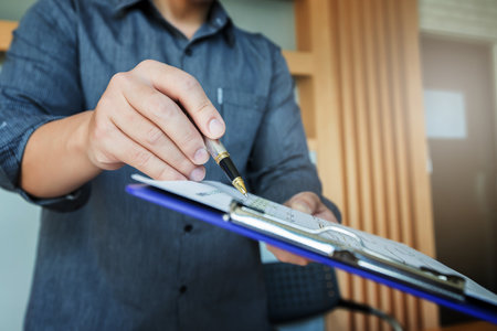 Businessman pointing to business chart present to his colleagues during meeting