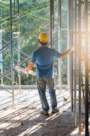 Engineer with blueprint in building construction site