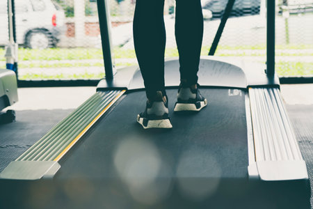 Woman legs on Treadmill or tracking machine in fitness centerの写真素材