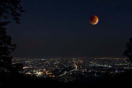Lunar eclipse over Chiang Mai city. Blood Moon in the lunar eclipse and also a Blue Moon and super moon called Super Blue Blood Moonの写真素材