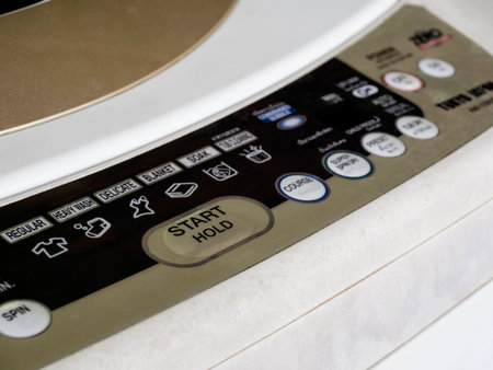 Close up of control panel at front of top loading washing machine