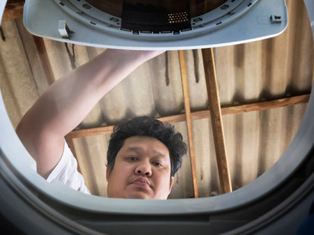 Man open the washing machine door, he doing Laundry.Inside view of washing machineの写真素材