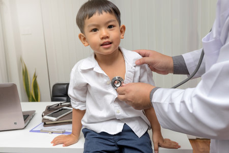 Pediatrician is diagnosing little patient using a stethoscopeの写真素材