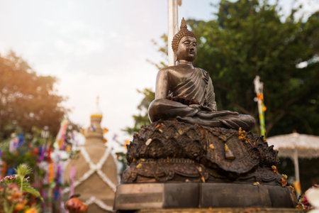Closeup of statue of Buddha with sand pagoda background at temple in Songkran Festivalの写真素材