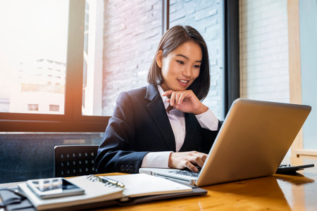 Closeup of businesswoman using laptop at office desk. She searching web or browsing information.の写真素材