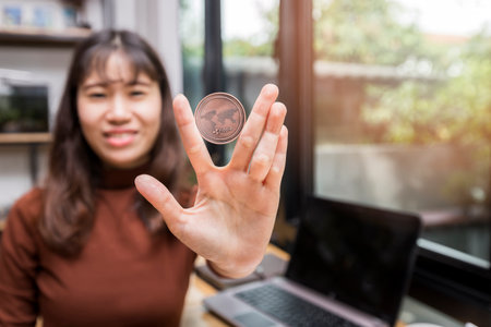 Copper Ripple coin (cryptocurrency) in hand of businesswoman. New Virtual money concept