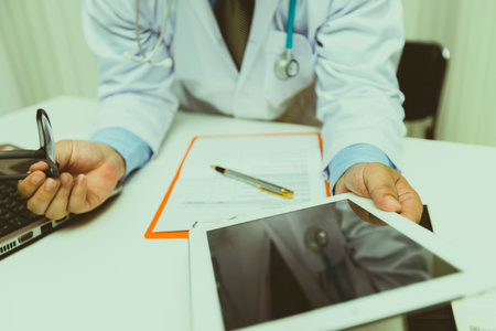 Doctor working with tablet computer at desk. Technology and medical concept.の写真素材