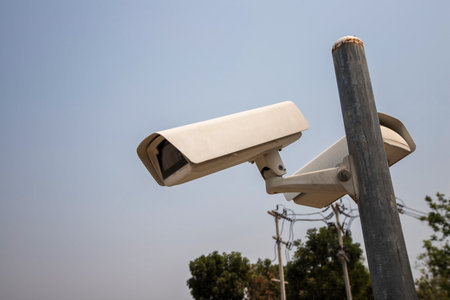CCTV camera in security system in urban city with sky background in security conceptの写真素材
