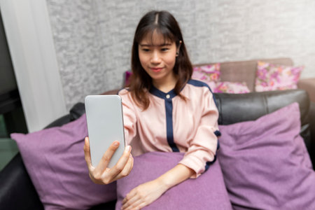 Close up happy young Asian businesswoman taking selfie photo with her mobile phone.の写真素材