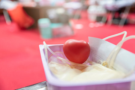 A red heart bouncy ball with blood bag in basket. Healthcare and charity. Blood donation conceptの写真素材