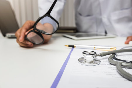 Close-up of stethoscope is lying on the clipboard in front of  a doctor.の写真素材