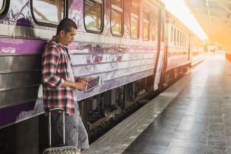 Traveler with baggage and digital tablet in train station. Travel concept.