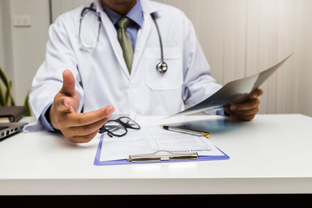 A doctor consults patient while sitting at the table in office. Medicine and health care concept.