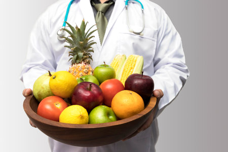 Doctor holding basket assort fresh fruits and vegetables isolated on white background.の写真素材
