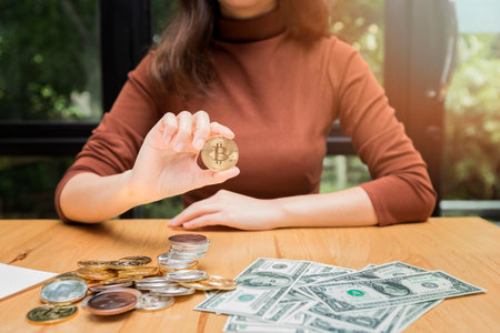 Golden bitcoin (cryptocurrency) in hand of businesswoman. New Virtual money conceptの写真素材